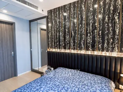 Modern bedroom with stylish accent wall and mirrored closet doors