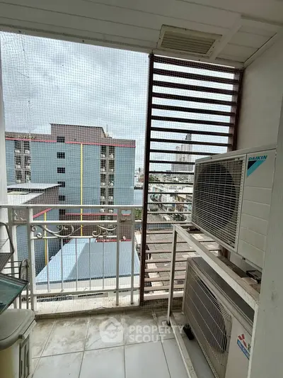 Urban balcony with city view and air conditioning units, perfect for modern living.