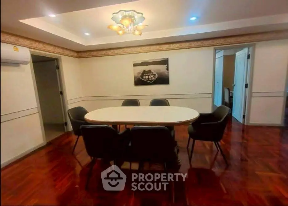 Elegant dining room with modern chandelier and wooden flooring, perfect for family gatherings.