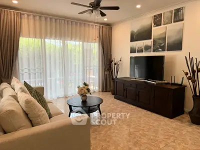 Elegant living room with large windows, stylish decor, and comfortable seating.