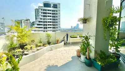 Spacious balcony with city view and lush greenery in modern apartment