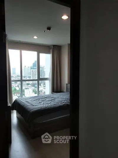 Cozy bedroom with city view in modern high-rise apartment