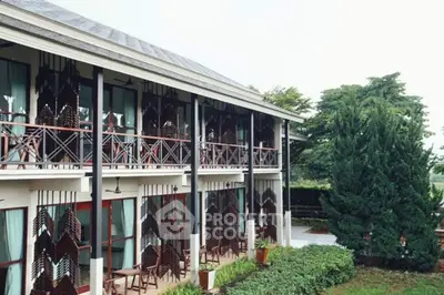 Charming two-story building with unique wooden facade and lush greenery.