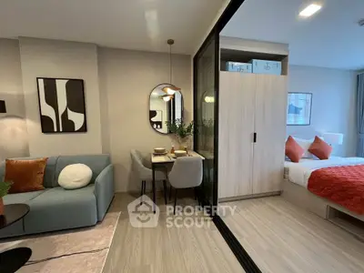 Modern open-plan living room with stylish decor and cozy bedroom in a chic apartment.
