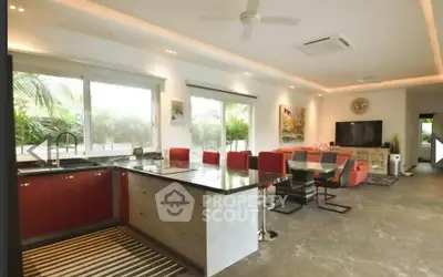 Spacious open-layout living room with modern kitchen and stylish decor, perfect for entertaining.