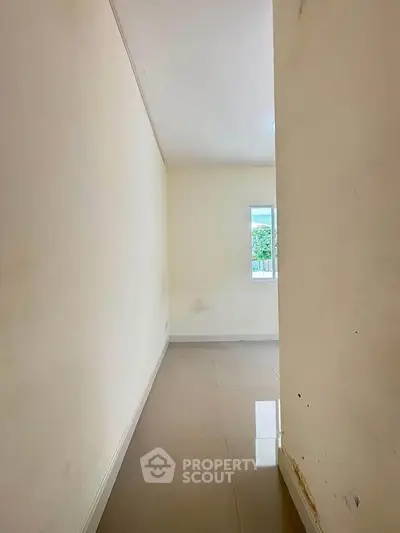 Minimalist hallway leading to a bright room with a window view, perfect for creative interior design ideas.
