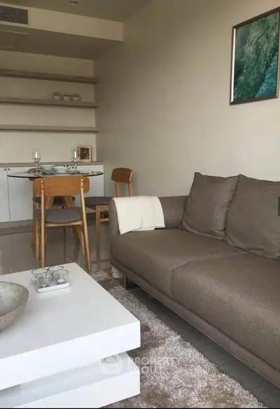 Modern living room with cozy sofa and stylish dining area in open layout apartment.