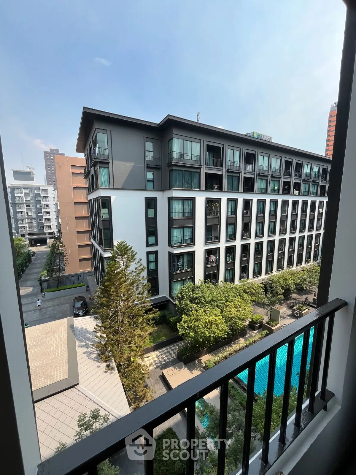 Modern apartment building with pool view from balcony, ideal urban living.