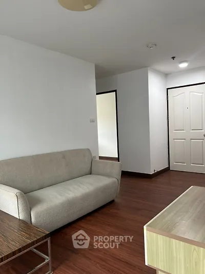 Modern living room with sleek wooden flooring and minimalist furniture design.