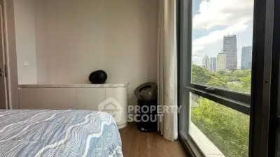 Modern bedroom with city view, featuring stylish decor and large window overlooking skyline.