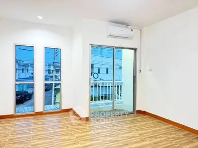 Spacious empty room with large windows and balcony access, perfect for customization.