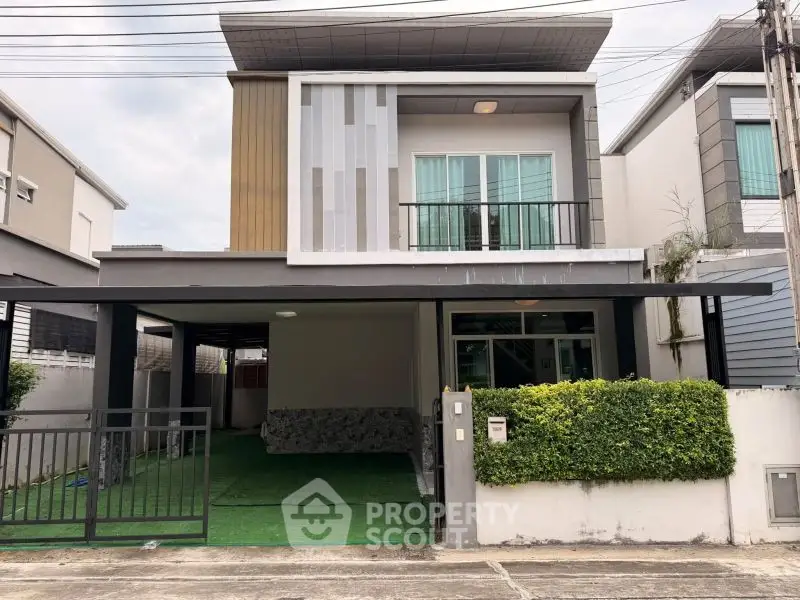 Modern two-story house with unique facade and spacious carport in a suburban neighborhood.