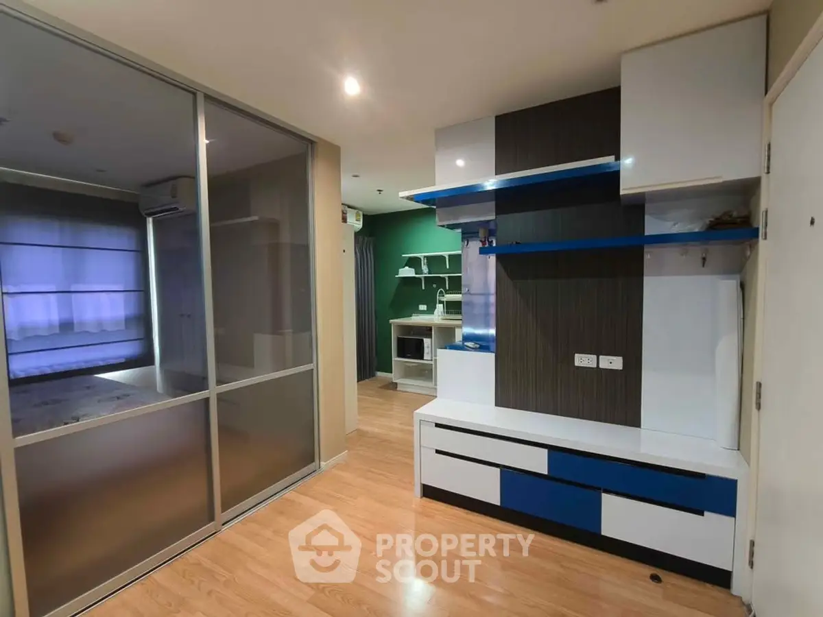 Modern apartment interior with stylish built-in furniture and sliding glass doors.