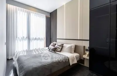 Modern bedroom with sleek design and ample natural light from large windows.