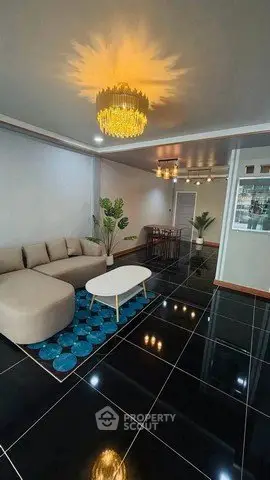Luxurious living room with modern chandelier and sleek black tile flooring