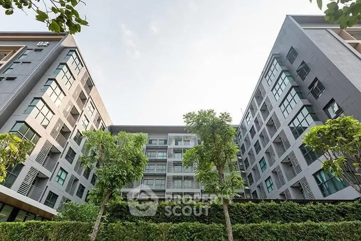 Modern apartment building with lush greenery and contemporary design.