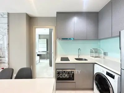Modern kitchen with sleek cabinetry, integrated appliances, and a washing machine, perfect for urban living.