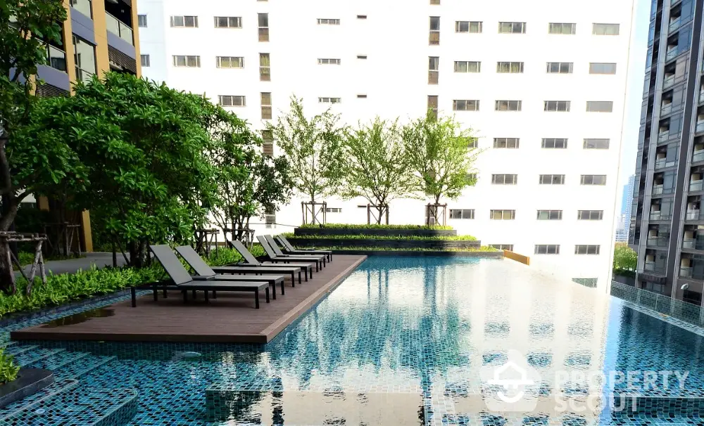 Luxurious rooftop pool with sun loungers and city view in modern apartment complex