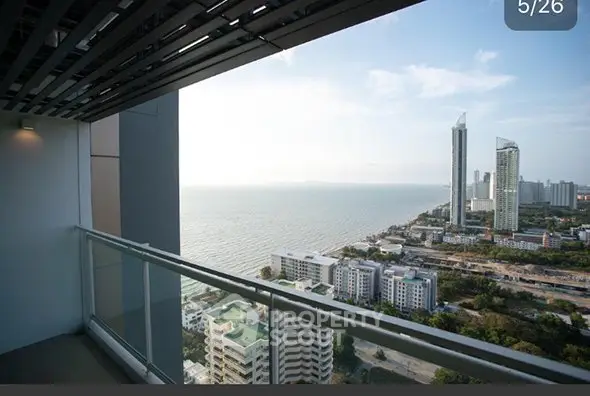 Stunning ocean view from high-rise balcony overlooking city skyline and coastline.