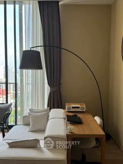 Modern living room with stylish furniture and city view, featuring a cozy sofa and elegant floor lamp.