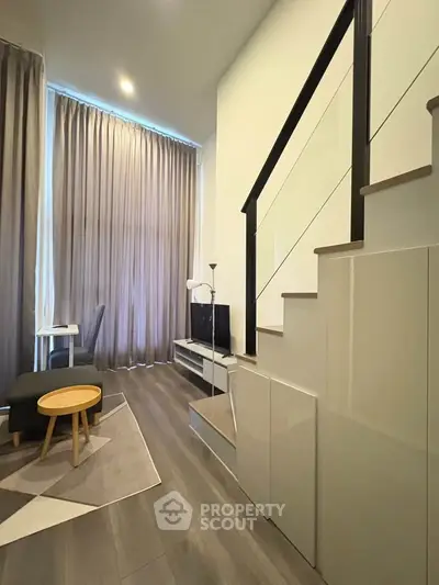 Modern duplex living room with high ceilings and stylish staircase