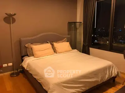 Cozy bedroom with city view, featuring a comfortable bed and elegant decor, perfect for relaxation.
