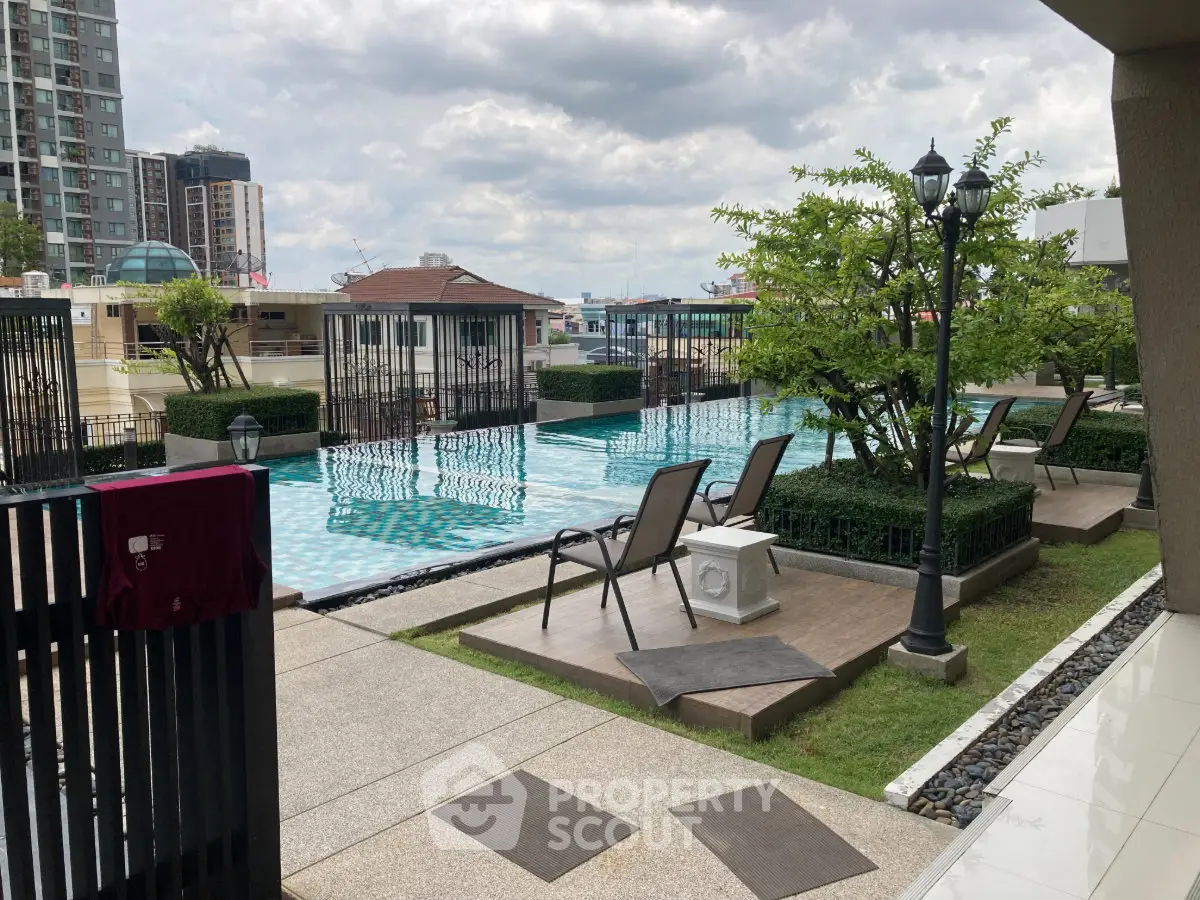 Luxurious outdoor pool area with stylish seating and lush greenery, perfect for relaxation and leisure.