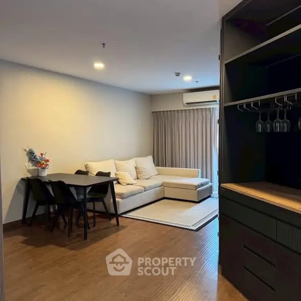 Modern living room with cozy sofa and dining area in open layout apartment.