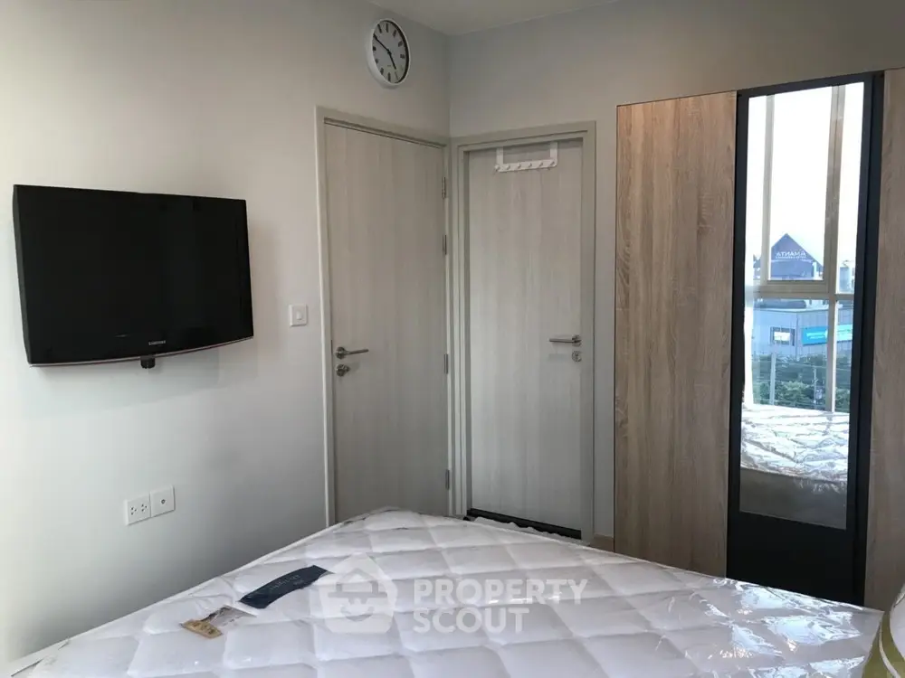 Modern bedroom with wall-mounted TV and large wardrobe