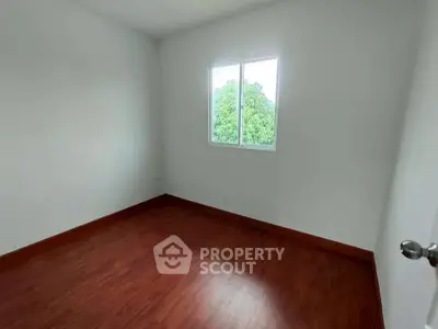 Bright empty room with wooden flooring and large window view
