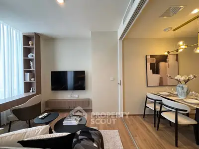 Modern living room with stylish decor and dining area, featuring sleek furniture and elegant lighting.