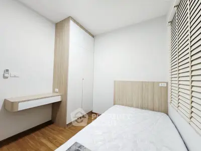 Modern minimalist bedroom with wooden flooring and built-in wardrobe