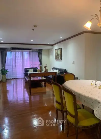 Spacious living room with elegant dining area and large windows in a modern apartment.