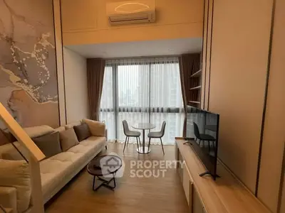 Modern living room with large window, cozy sofa, and stylish decor in a high-rise apartment.