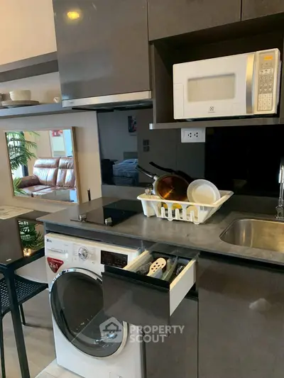 Modern kitchen with built-in appliances and sleek cabinetry in a compact layout.