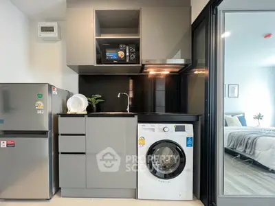 Modern kitchen with sleek appliances and washing machine in compact layout