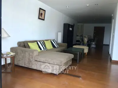 Spacious living room with modern sofa and wooden flooring in a stylish apartment.