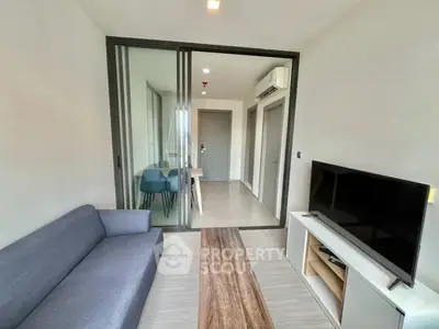 Modern living room with sleek furniture and glass partition in a stylish apartment.
