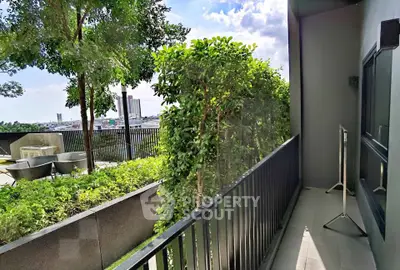 Spacious balcony with lush greenery and city view, perfect for relaxation and outdoor enjoyment.