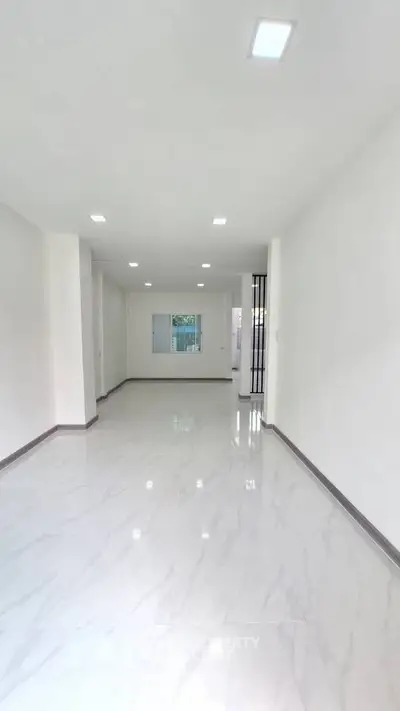Spacious empty room with white walls and marble flooring, ideal for customization.