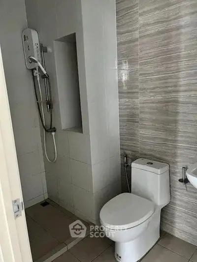 Modern bathroom with sleek shower and toilet in contemporary design.