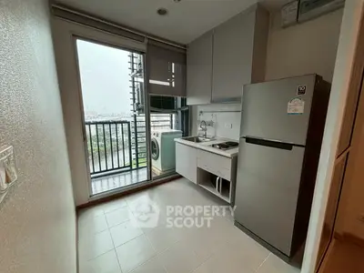 Modern kitchen with balcony view, featuring sleek appliances and ample natural light.