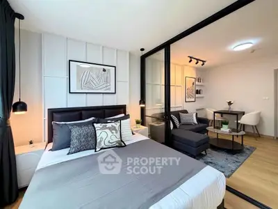 Modern bedroom with stylish decor and adjacent living area in open-plan apartment.