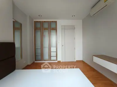 Modern bedroom with wooden flooring and built-in wardrobe