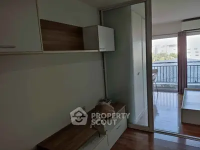 Modern apartment interior with sliding glass door leading to a balcony with a view.