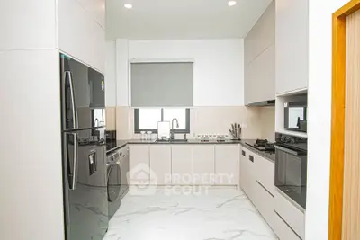 Modern kitchen with sleek appliances and marble flooring in a contemporary home.