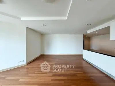 Spacious open-plan living area with modern wooden flooring and sleek design.