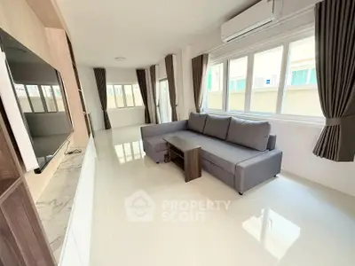 Spacious modern living room with large windows and sleek furniture
