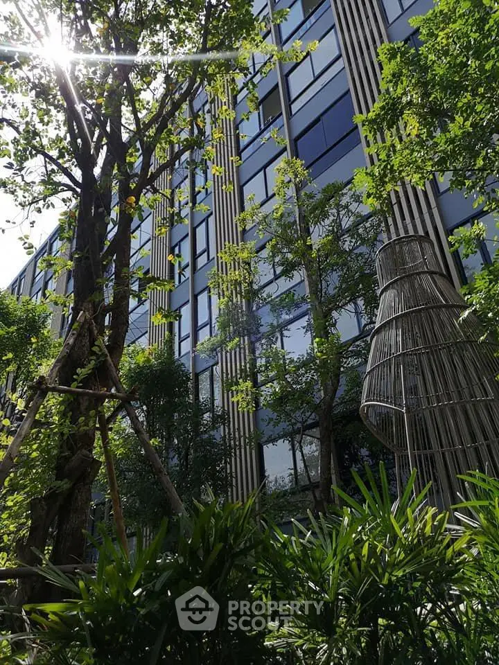 Modern building exterior with lush greenery and unique architectural design.