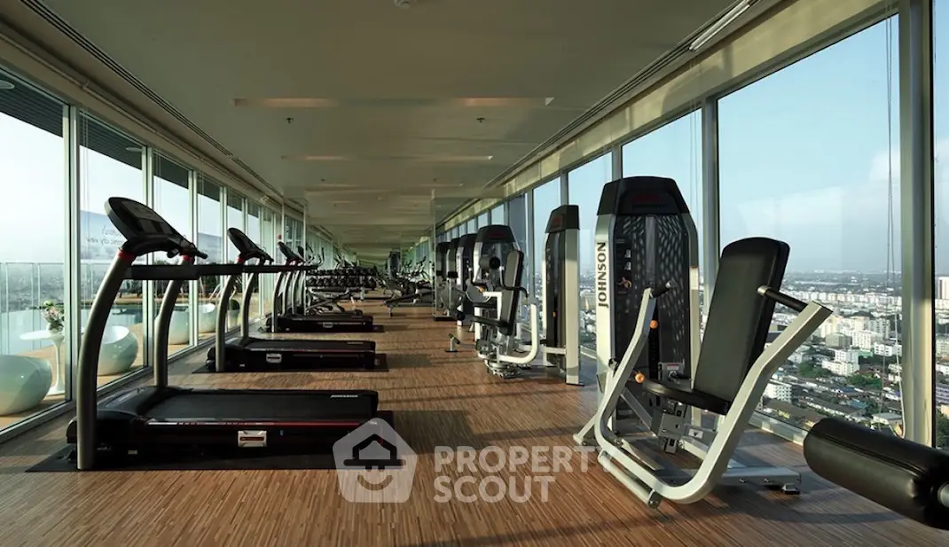 Luxurious high-rise gym with panoramic city views and modern fitness equipment.